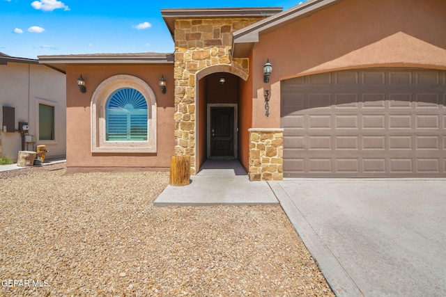 view of front facade with stone siding, an attached garage, stucco siding, and concrete driveway