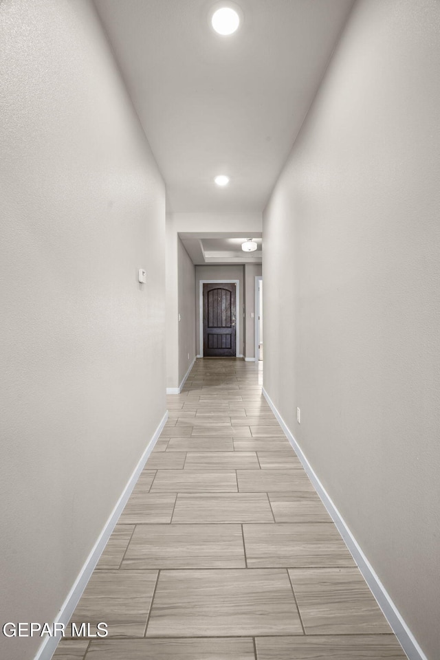 corridor featuring baseboards and recessed lighting