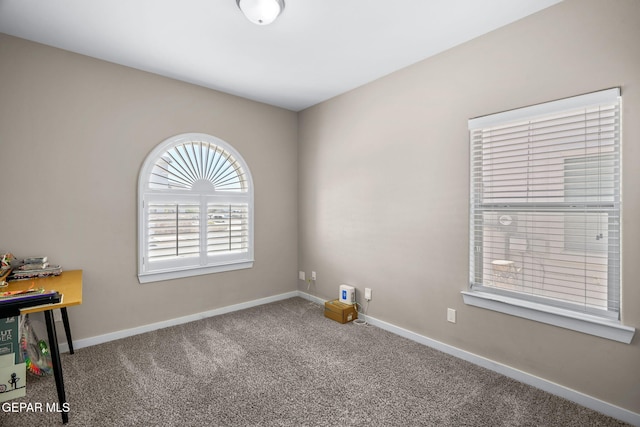 unfurnished room with carpet floors and baseboards