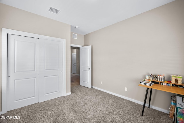 carpeted bedroom with baseboards and a closet
