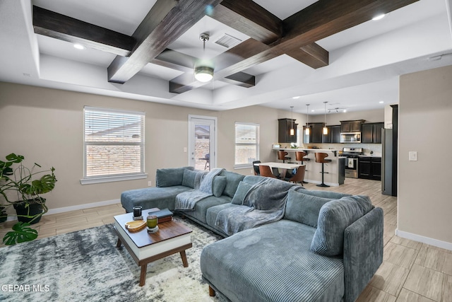 living area featuring coffered ceiling, baseboards, a ceiling fan, beam ceiling, and light wood finished floors