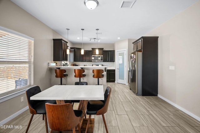 dining area featuring baseboards, healthy amount of natural light, and wood tiled floors