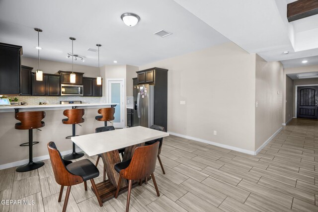 dining room featuring baseboards, wood finish floors, and recessed lighting