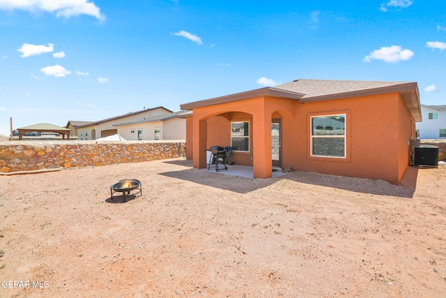 back of property featuring an outdoor fire pit, cooling unit, a patio, stucco siding, and fence