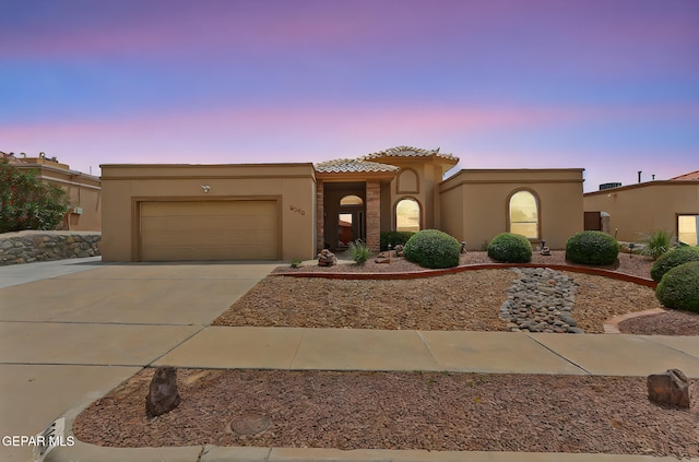 7008 Desert Canyon Dr, El Paso, TX 79912 - view of front of house with concrete driveway, stucco siding, an attached garage, and a tiled roof