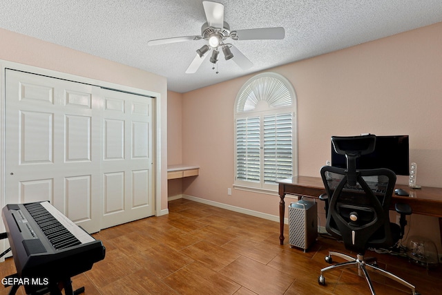 7008 Desert Canyon Dr, El Paso, TX 79912 - office featuring a textured ceiling, ceiling fan, wood finished floors, and baseboards