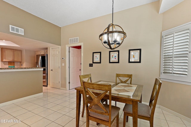 7008 Desert Canyon Dr, El Paso, TX 79912 - dining area featuring light tile patterned flooring, a chandelier, baseboards, and a towering ceiling