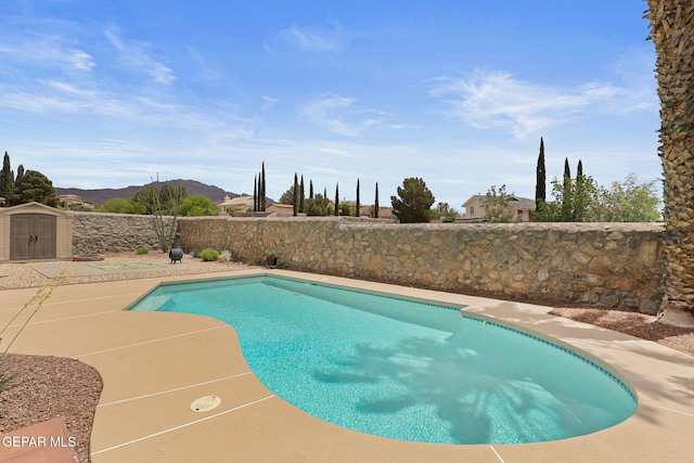 7008 Desert Canyon Dr, El Paso, TX 79912 - view of pool with a mountain view, a storage shed, an outbuilding, a fenced backyard, and a patio area