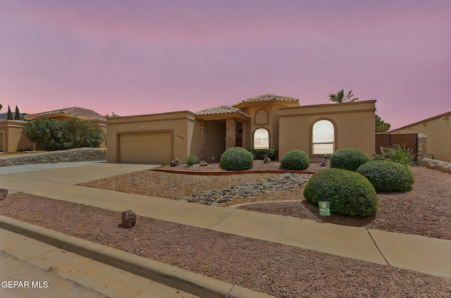 7008 Desert Canyon Dr, El Paso, TX 79912 - mediterranean / spanish home with stucco siding, an attached garage, a tile roof, and driveway