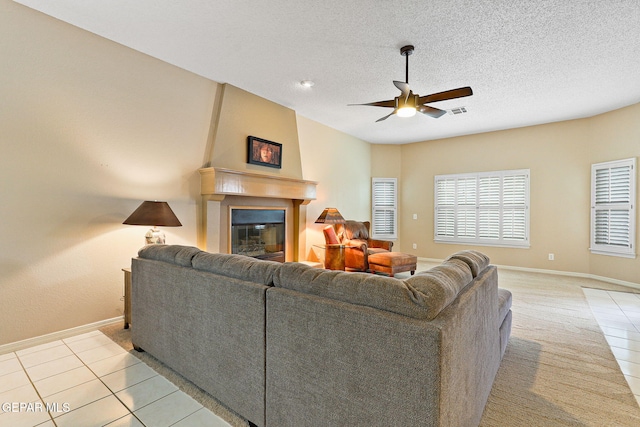 7008 Desert Canyon Dr, El Paso, TX 79912 - living area with ceiling fan, baseboards, light tile patterned floors, a fireplace, and a textured ceiling