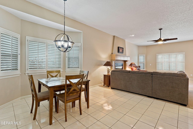 7008 Desert Canyon Dr, El Paso, TX 79912 - dining area with a chandelier, ceiling fan, a textured ceiling, light tile patterned flooring, and baseboards