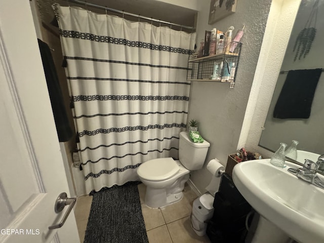 10620 Cuatro Vistas Dr Unit A, El Paso, TX 79935 - bathroom with toilet, tile patterned floors, a textured wall, and a sink