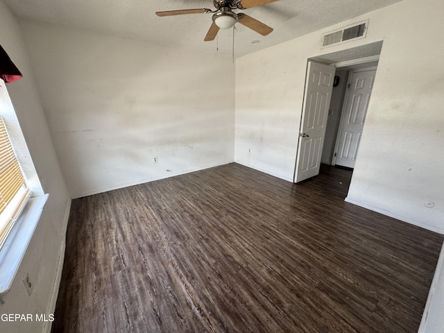 10620 Cuatro Vistas Dr Unit A, El Paso, TX 79935 - empty room with dark wood finished floors, ceiling fan, baseboards, and a textured ceiling