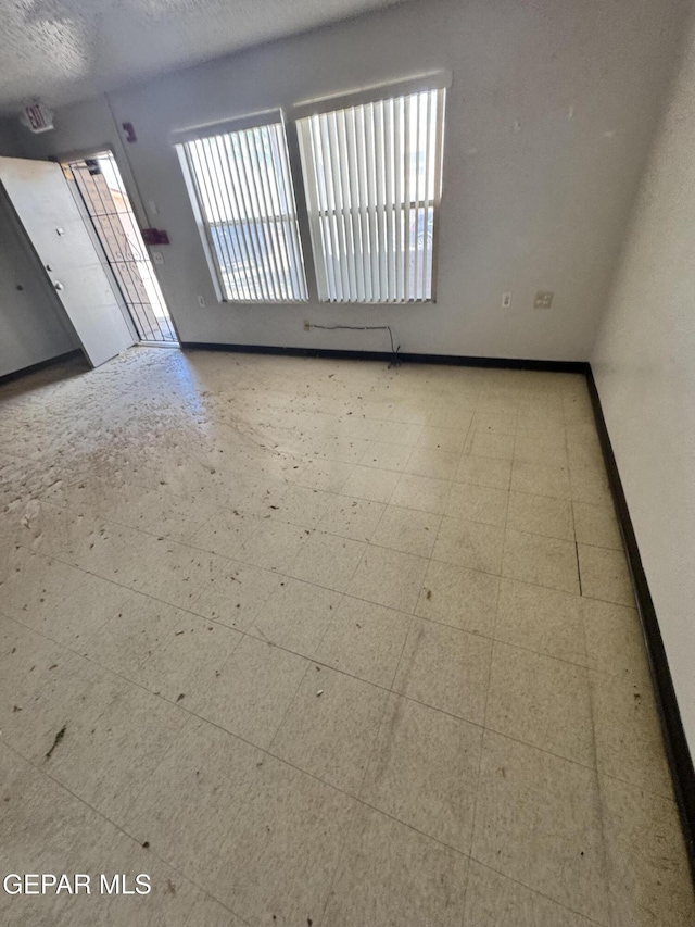 10620 Cuatro Vistas Dr Unit A, El Paso, TX 79935 - spare room featuring plenty of natural light, baseboards, and tile patterned floors