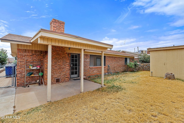 back of property featuring a chimney, brick siding, a patio, and board and batten siding