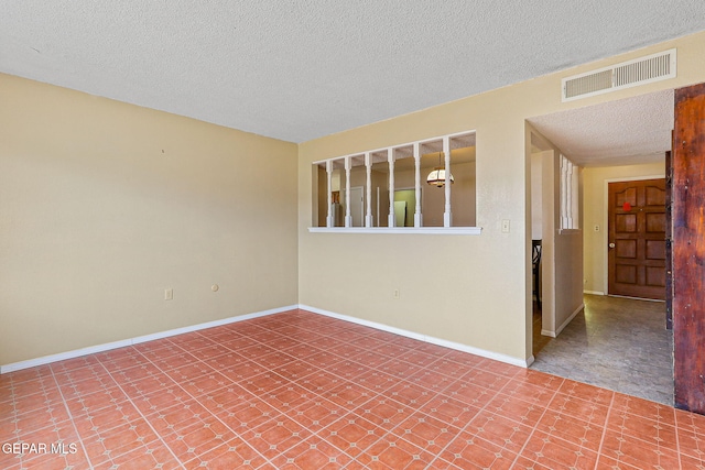 unfurnished room featuring a textured ceiling and baseboards