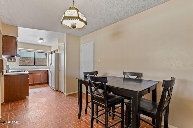 dining area with baseboards and a textured ceiling