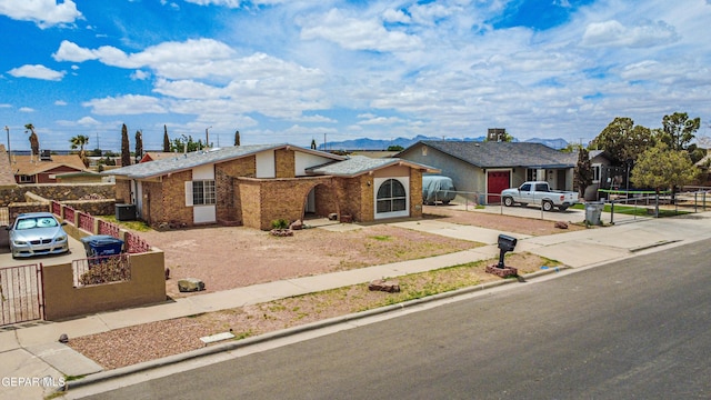 8520 Paddlefoot Ln, El Paso, TX 79907 - view of front facade with driveway, a gate, a mountain view, and brick siding