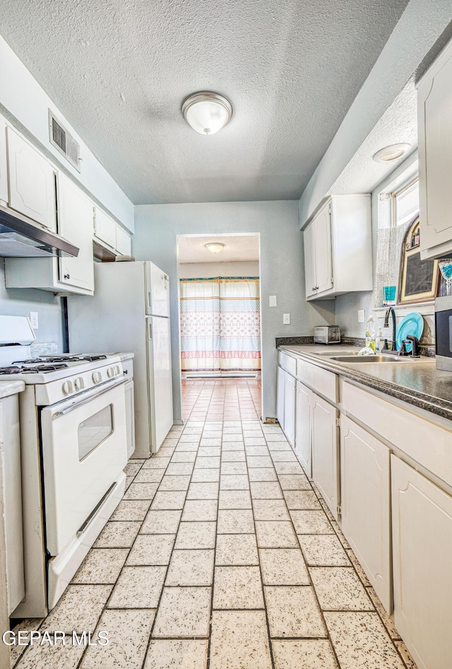 8520 Paddlefoot Ln, El Paso, TX 79907 - kitchen with white gas range oven, under cabinet range hood, a sink, white cabinetry, and a textured ceiling
