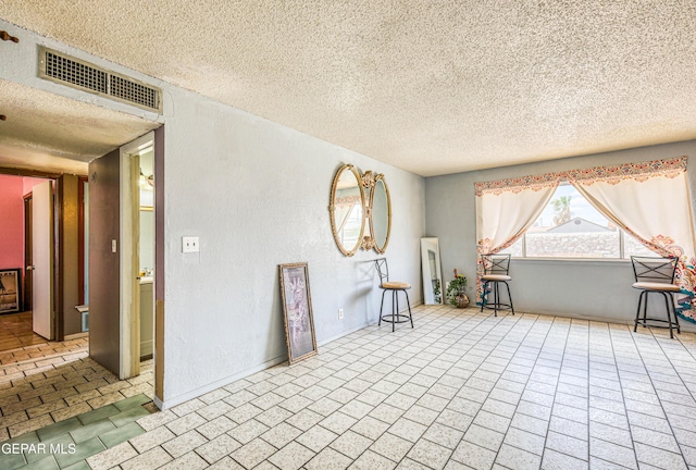 8520 Paddlefoot Ln, El Paso, TX 79907 - unfurnished room with a textured ceiling and brick patterned floors