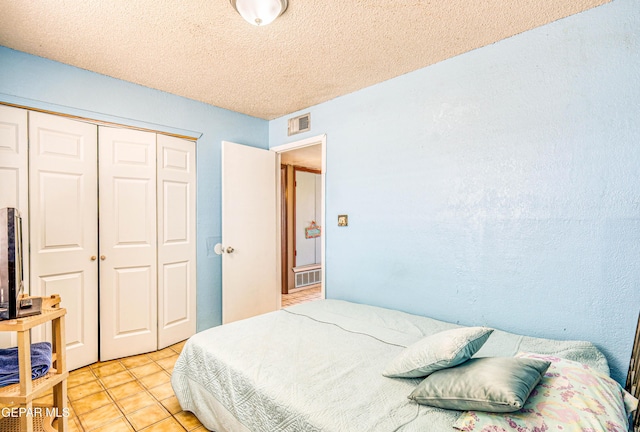 8520 Paddlefoot Ln, El Paso, TX 79907 - bedroom with a closet, light tile patterned floors, and a textured ceiling