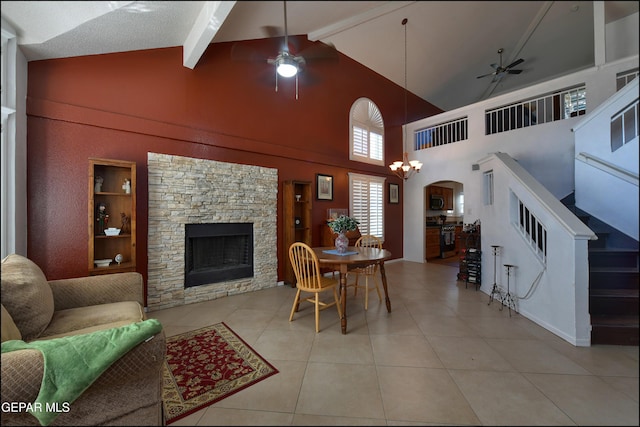living room featuring a ceiling fan, a stone fireplace, arched walkways, tile patterned flooring, and high vaulted ceiling