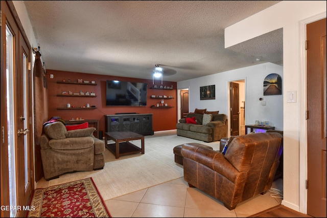 living area featuring a textured ceiling and light tile patterned floors