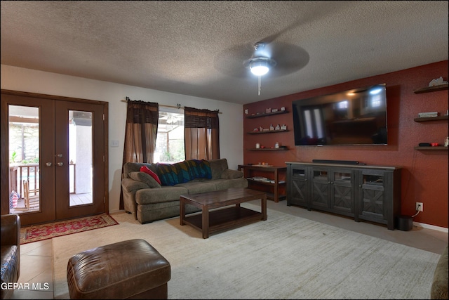 living area with ceiling fan, french doors, a textured ceiling, and baseboards
