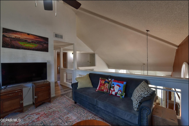 living room featuring ceiling fan, wood finished floors, a textured ceiling, high vaulted ceiling, and beam ceiling