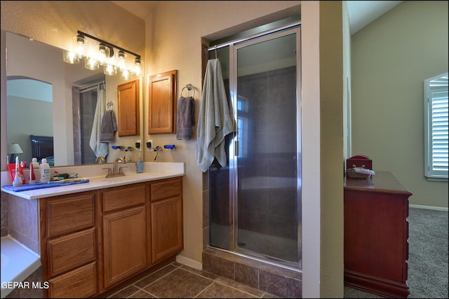 bathroom with a stall shower, vanity, and baseboards