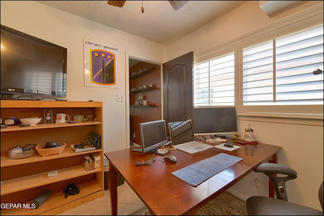 tiled office space with a ceiling fan and a textured ceiling