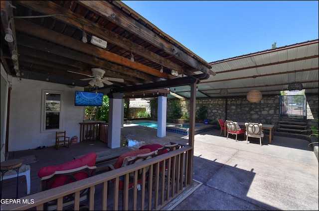 view of patio / terrace with a ceiling fan, a pool with connected hot tub, and a wooden deck