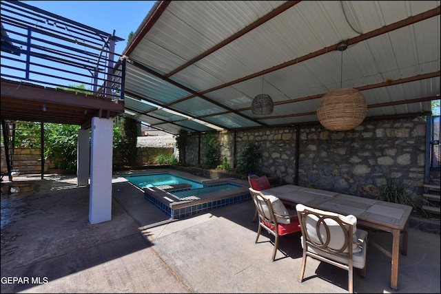 view of patio with an in-ground hot tub and stairway