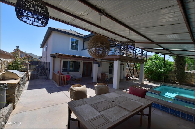 view of patio / terrace with an outdoor kitchen, outdoor dining space, fence, and a pool with connected hot tub