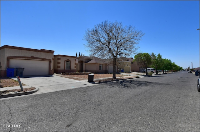 view of front of house with stucco siding, an attached garage, and concrete driveway