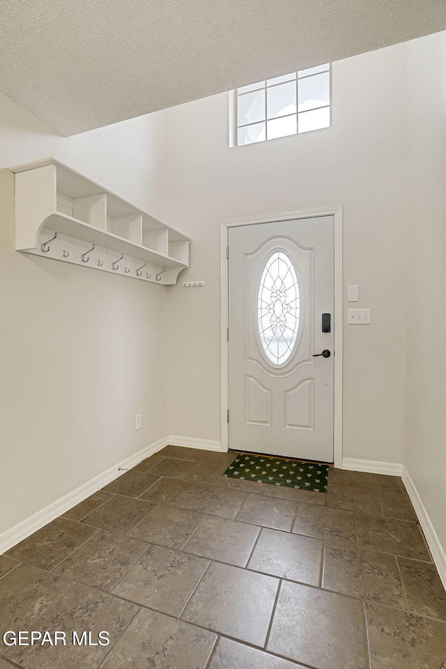 3136 Hawk Point Pl, El Paso, TX 79938 - foyer entrance with healthy amount of natural light, stone tile flooring, baseboards, and a textured ceiling