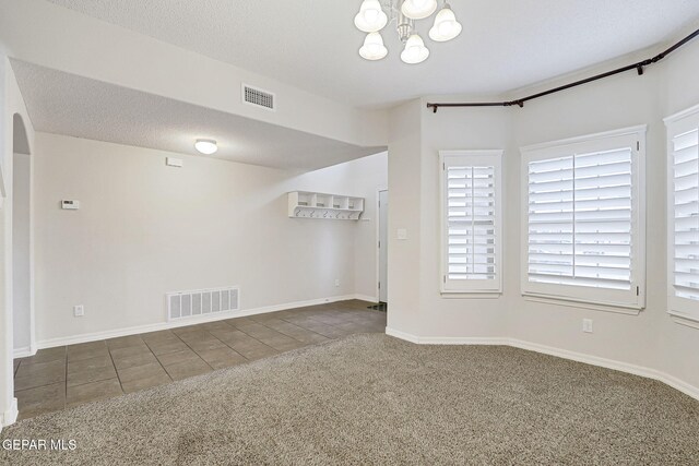 3136 Hawk Point Pl, El Paso, TX 79938 - carpeted empty room with tile patterned floors, a chandelier, baseboards, and arched walkways