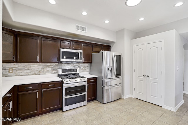 3136 Hawk Point Pl, El Paso, TX 79938 - kitchen with stainless steel appliances, dark brown cabinets, light countertops, backsplash, and baseboards