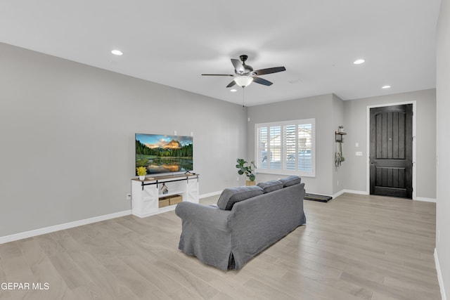 living room with a ceiling fan, baseboards, recessed lighting, and light wood-type flooring