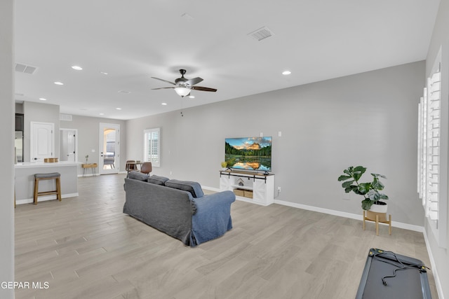 living area featuring light wood finished floors, a ceiling fan, recessed lighting, and baseboards