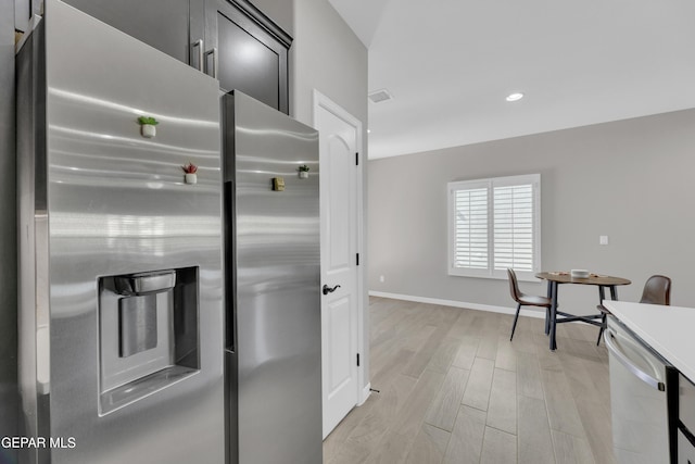 kitchen featuring stainless steel appliances, light wood finished floors, recessed lighting, baseboards, and light countertops