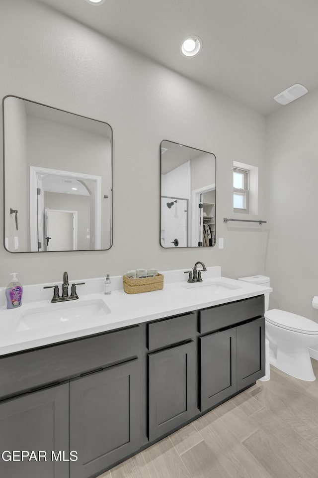 full bath featuring double vanity and toilet