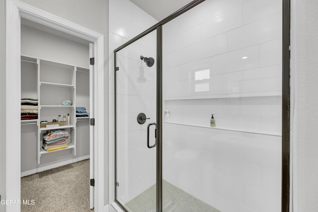 full bathroom with a spacious closet and a stall shower