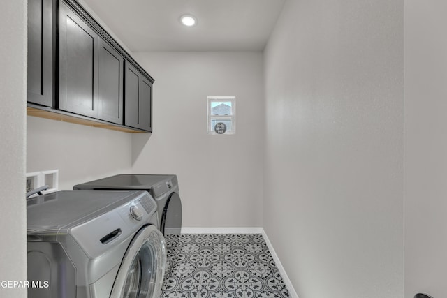 laundry room featuring separate washer and dryer, baseboards, and cabinet space