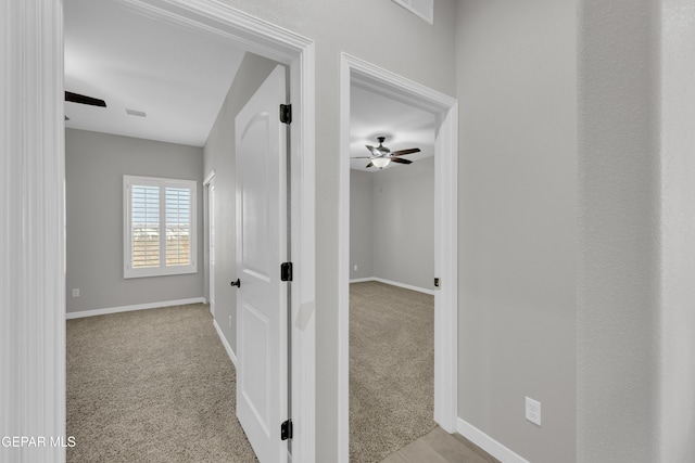 hall with baseboards and carpet floors