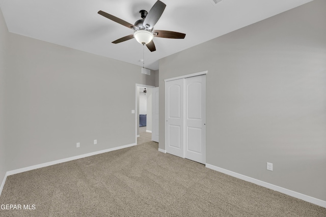 unfurnished bedroom featuring carpet, a closet, baseboards, and a ceiling fan
