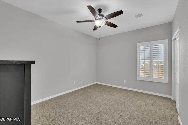 carpeted empty room with a ceiling fan and baseboards