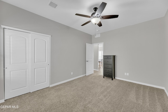 unfurnished bedroom with carpet, baseboards, a closet, and a ceiling fan
