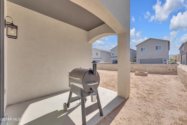 view of patio featuring a fire pit, a residential view, and fence