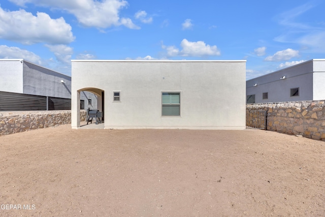 back of property featuring fence, stucco siding, and a patio